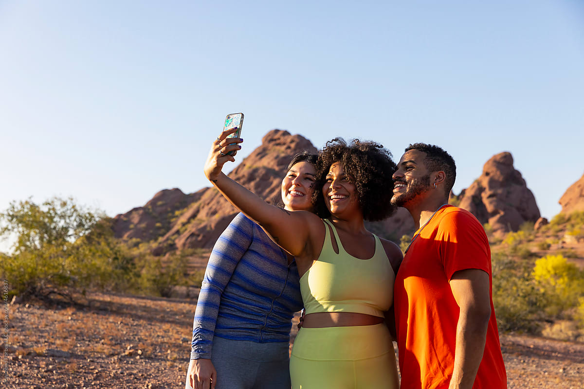 Group of Friends Hiking sunset in Arizona taking mobile phone selfie