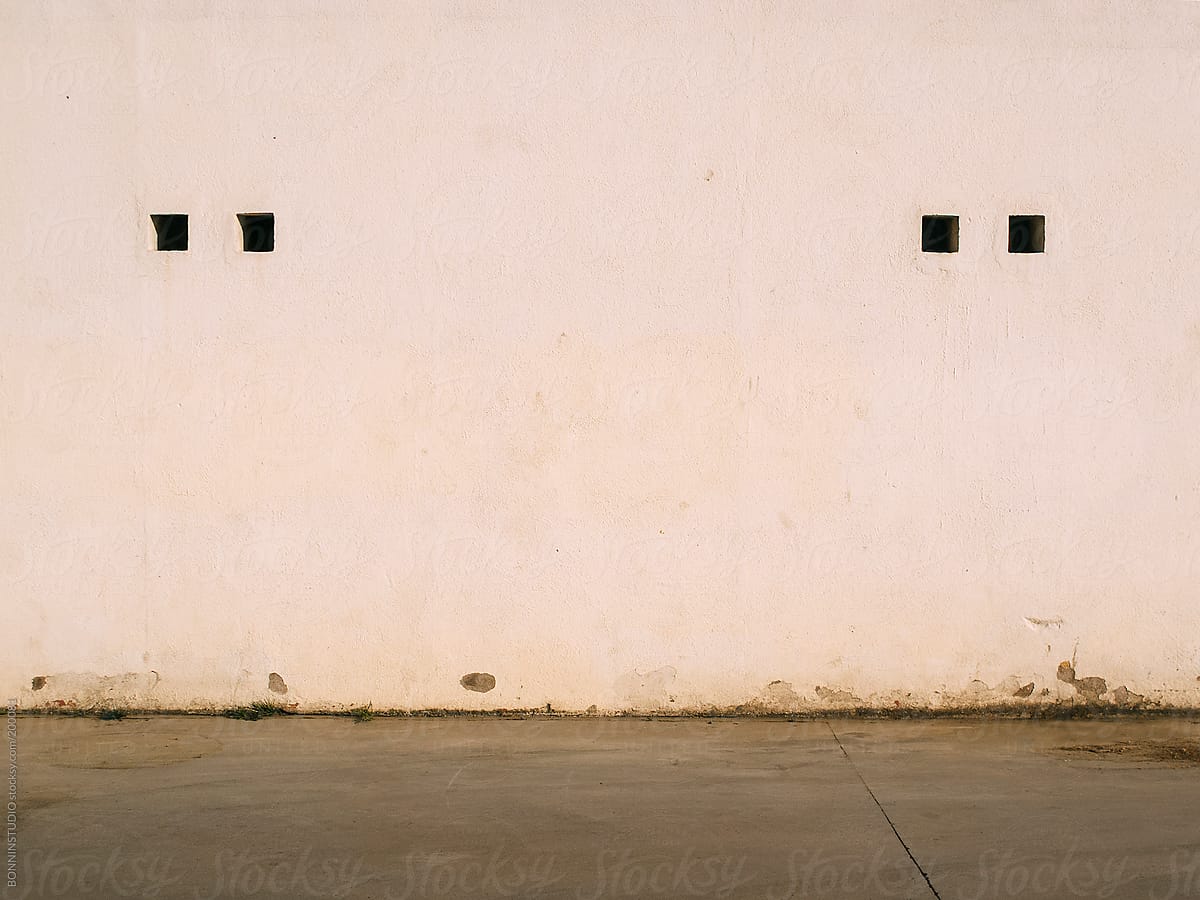 Small windows on wall shaped human face.