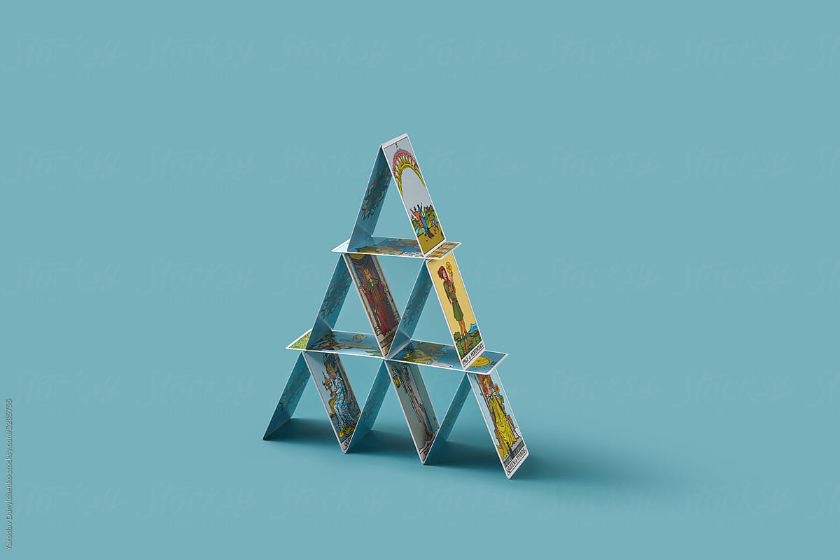 Pyramid made of tarot cards on blue background.