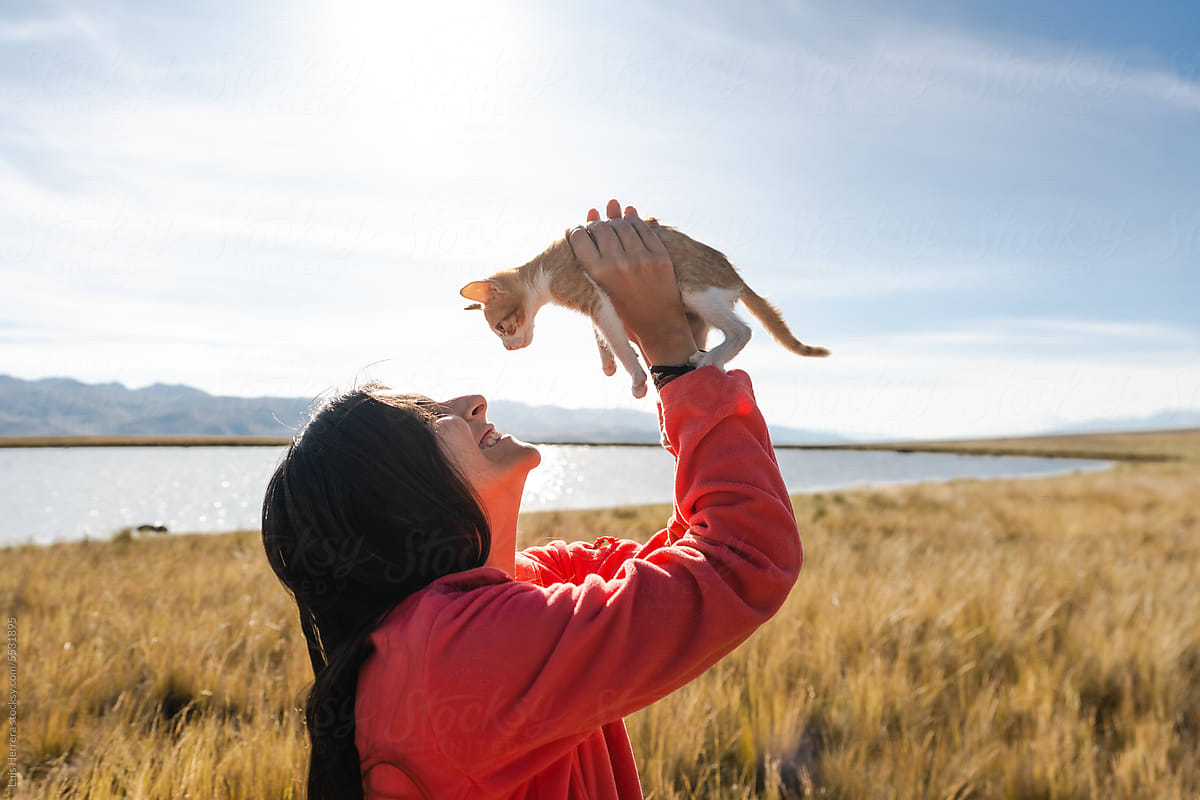 Happy Woman and Kitten bonding and Enjoying a Carefree Day outdoors