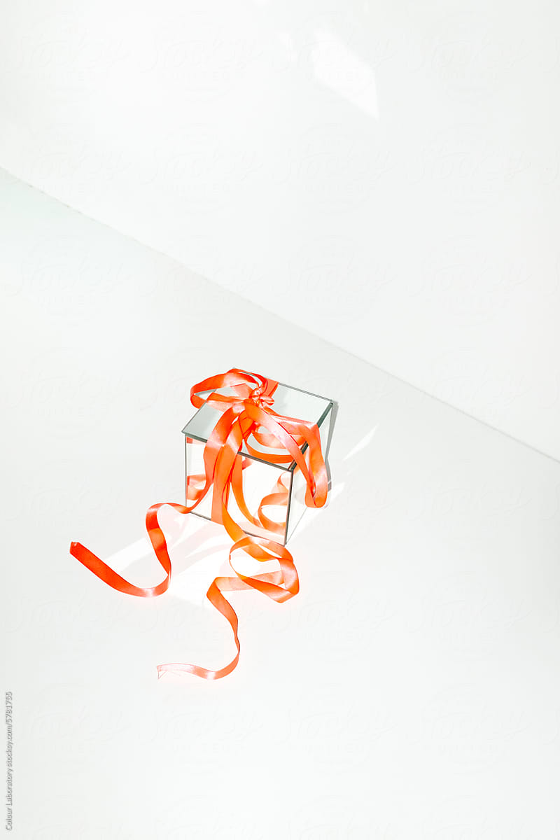 Contemporary photo of shiny mirror presents with neon silk ribbons