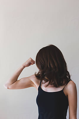 Thin Woman Flexing Her Arm Muscle - Horizontal by Stocksy Contributor  Jacqui Miller - Stocksy