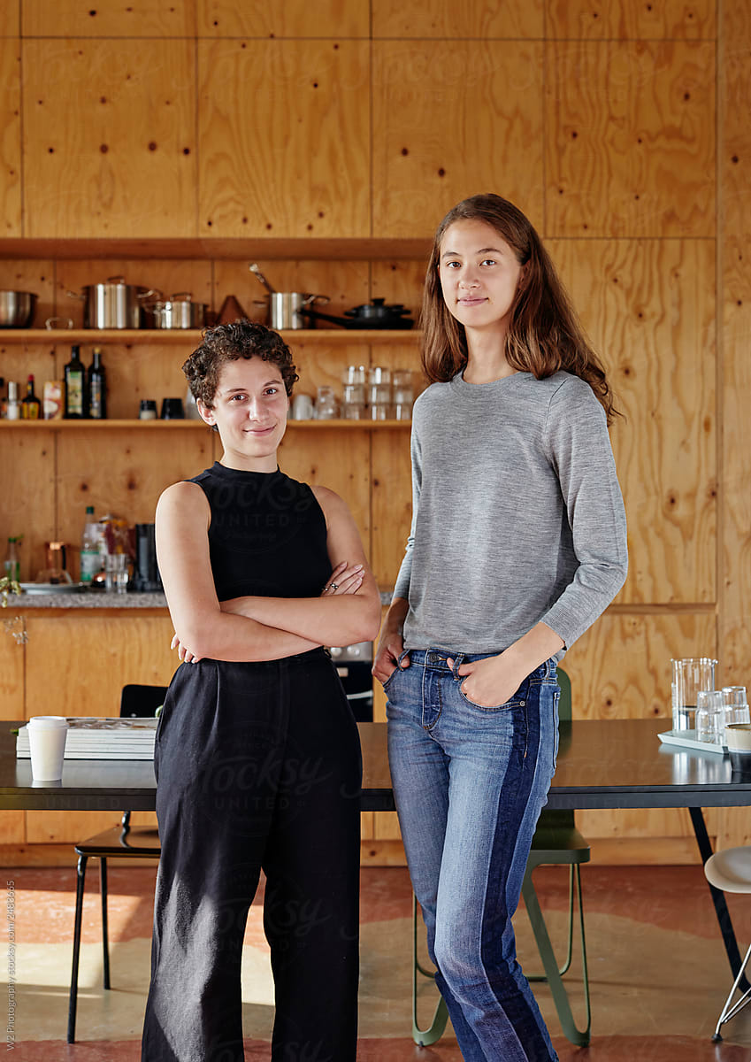 Portrait of two female students standing beside each other.