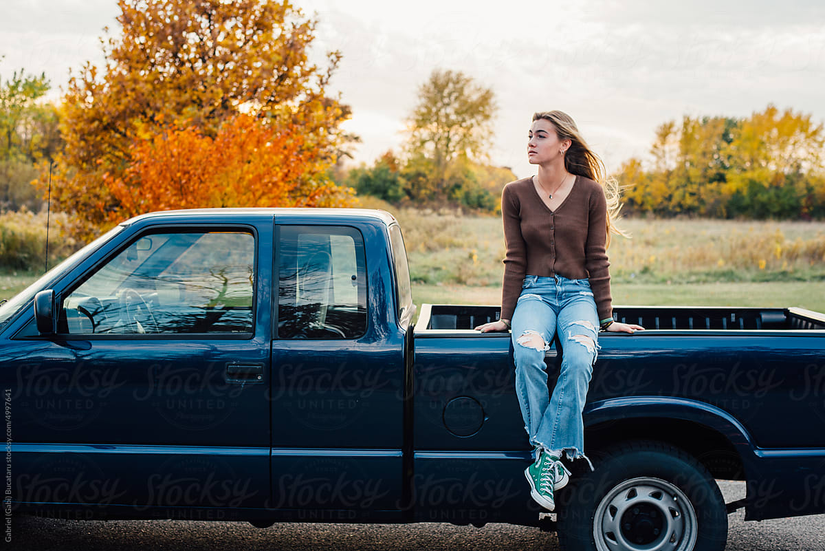 Teen girl sitting on truck