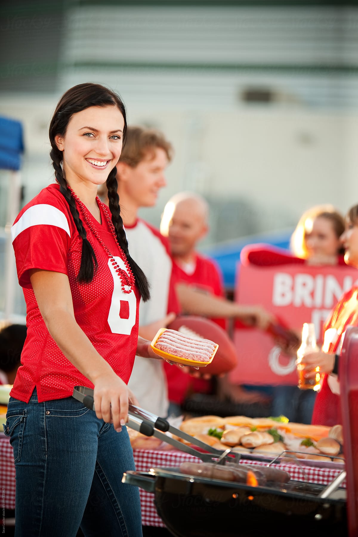 Tailgating: Woman Cooking Sausages on the Grill