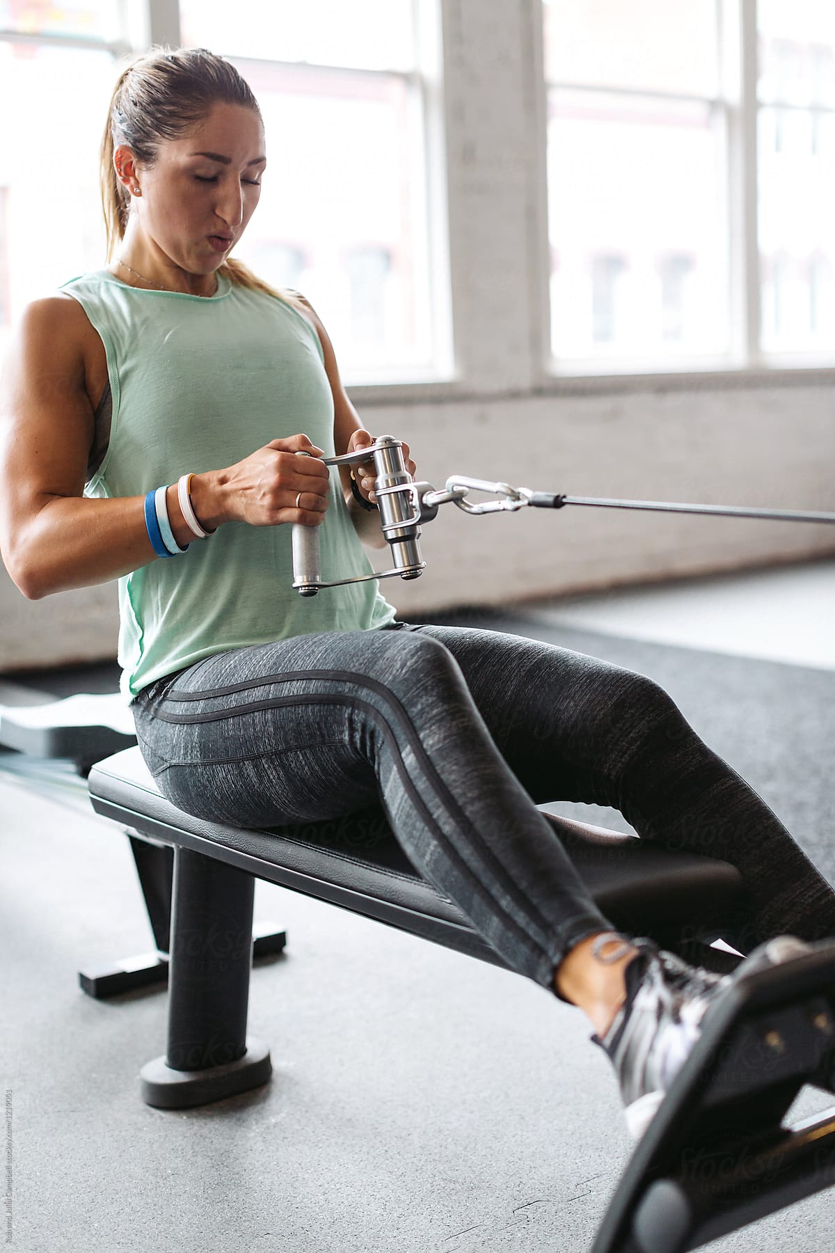 Strong, healthy woman working out in gym - rowing machine