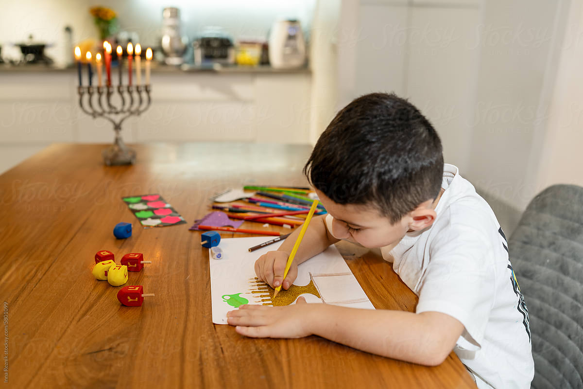 Traditional Menorah, Boy Drawing Holiday Hanukkah Card in Background.