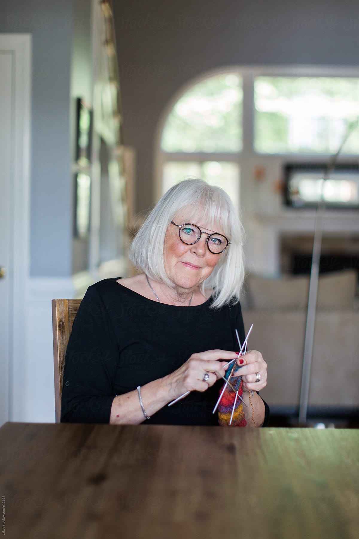 Senior woman knitting by a table