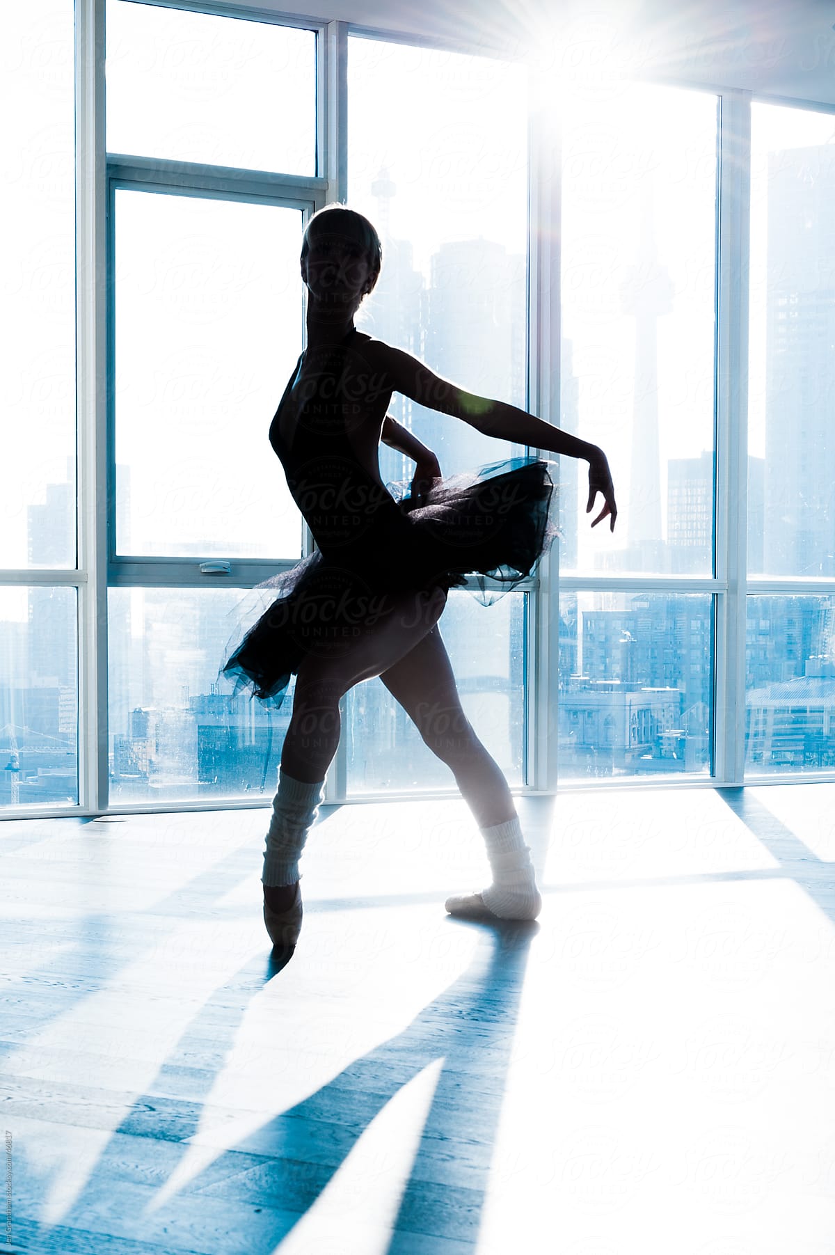 Ballerina in silhouette in front of a window