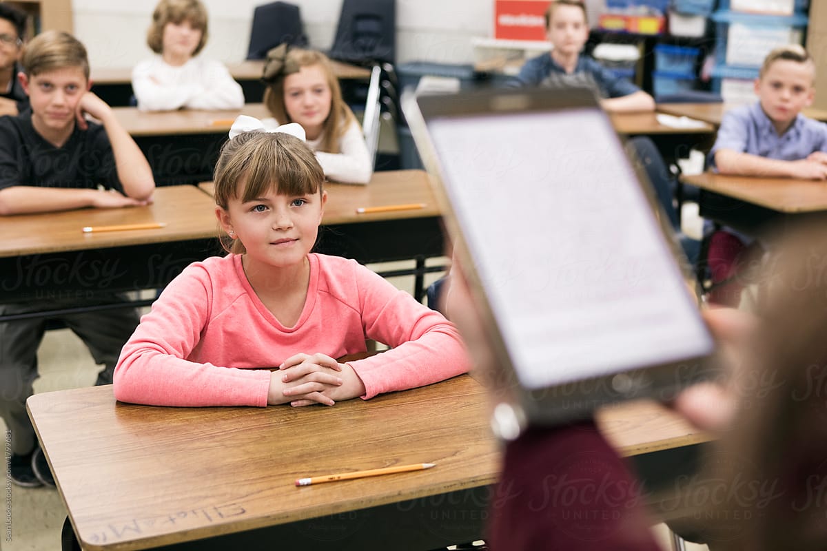 Classroom: Young Girl Listens As Teacher Reads