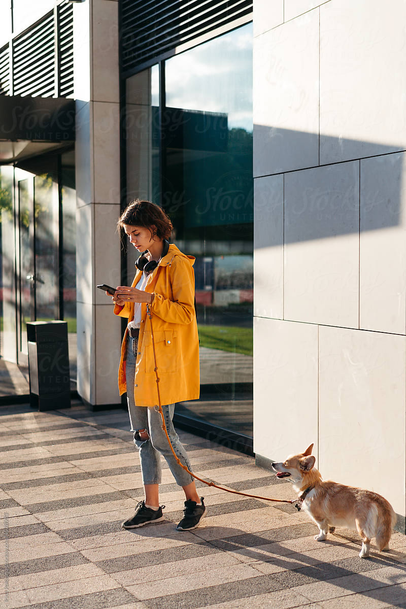 Female with dog in city.