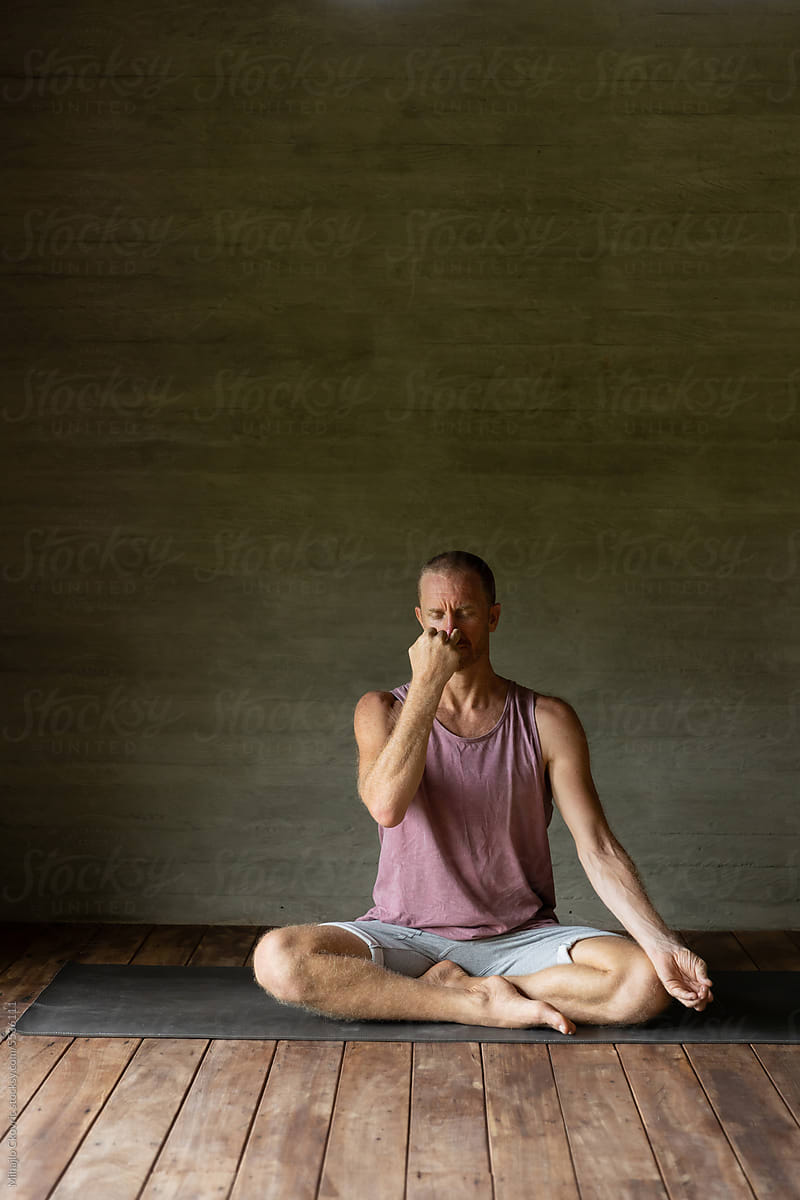 Adult yogi male doing breathing exercises