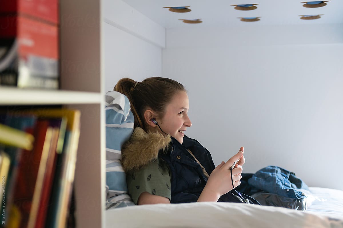 young teen girl listing to music in her room alone