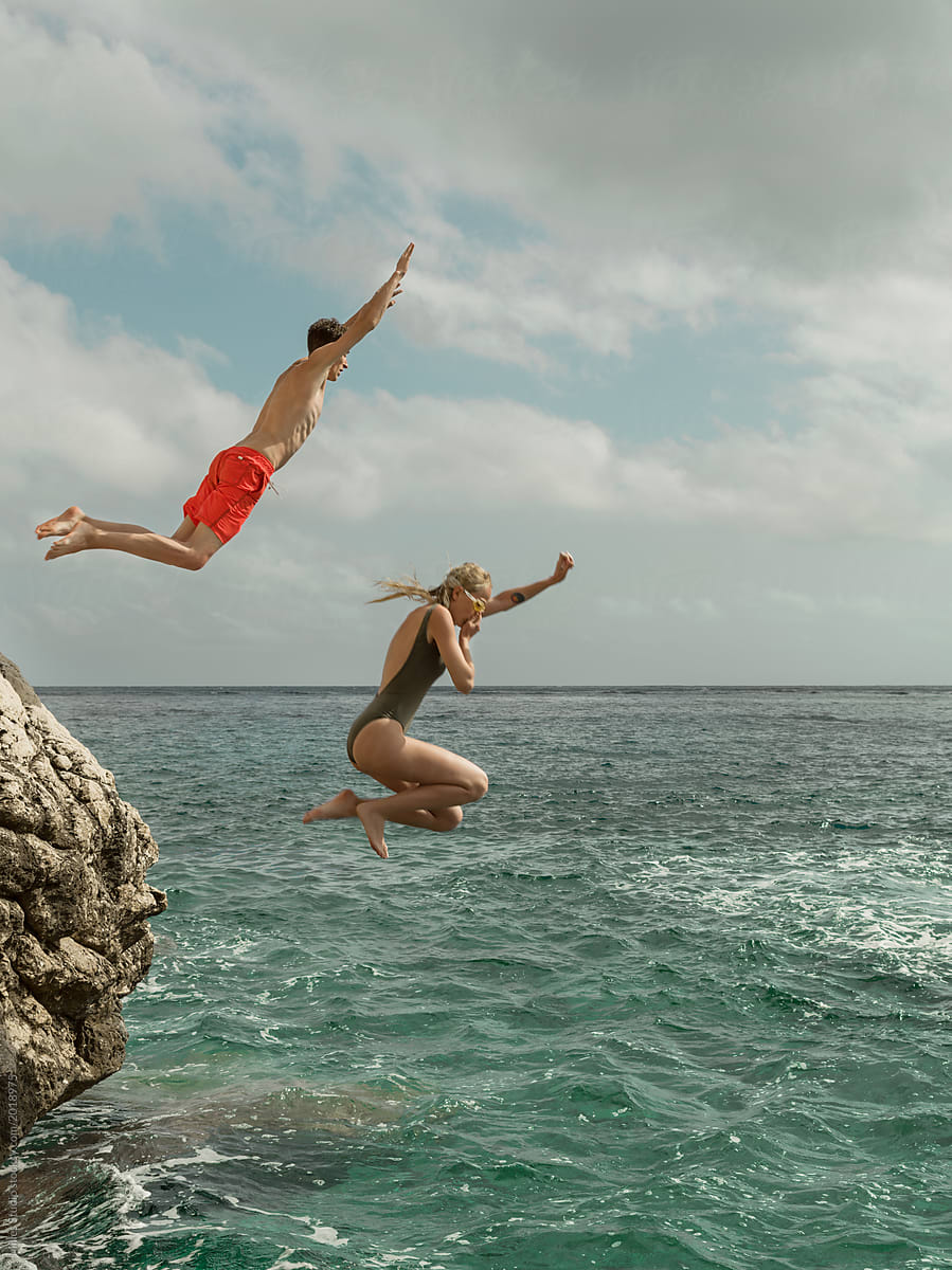 Couple falling into turquoise water of ocean