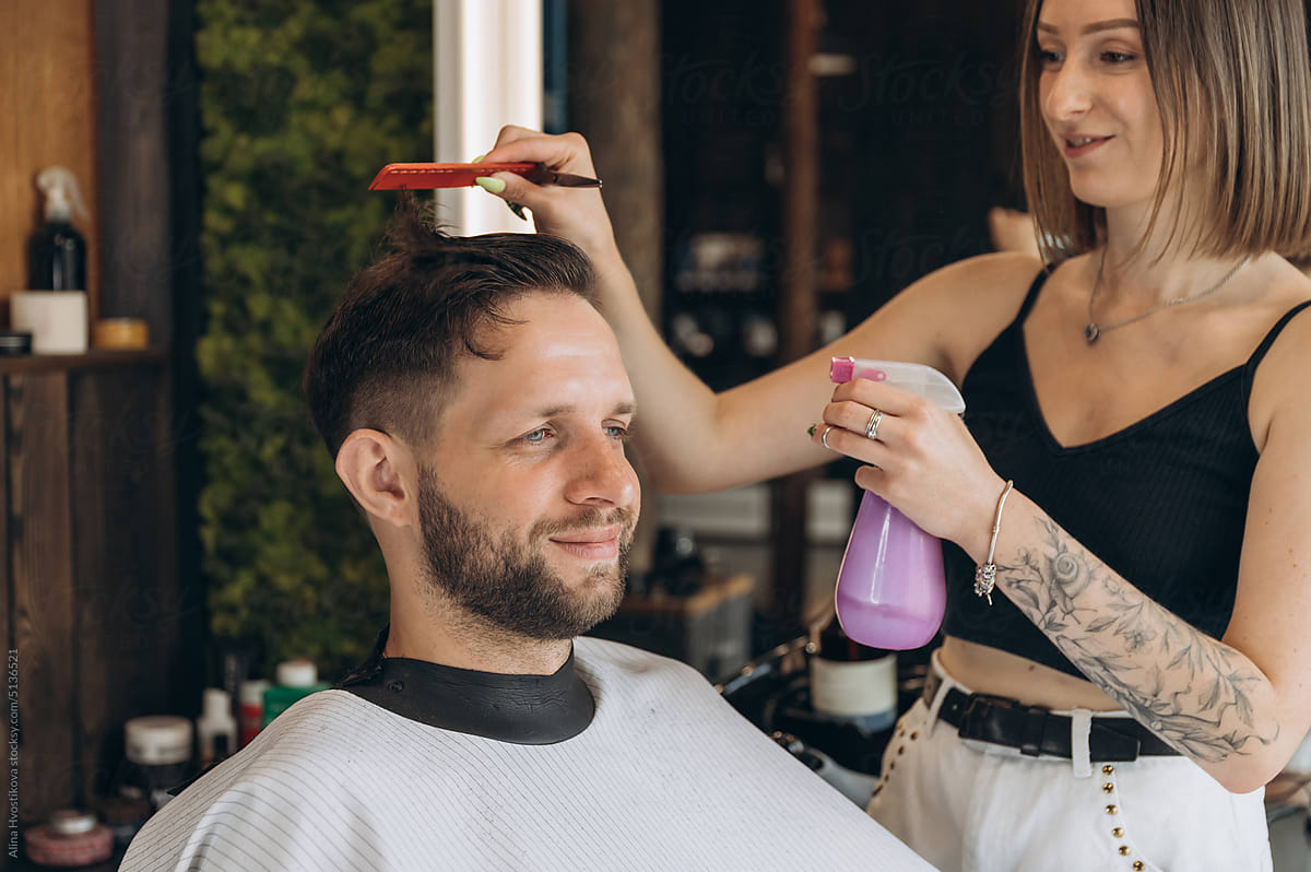 Barber spraying water on clients hair