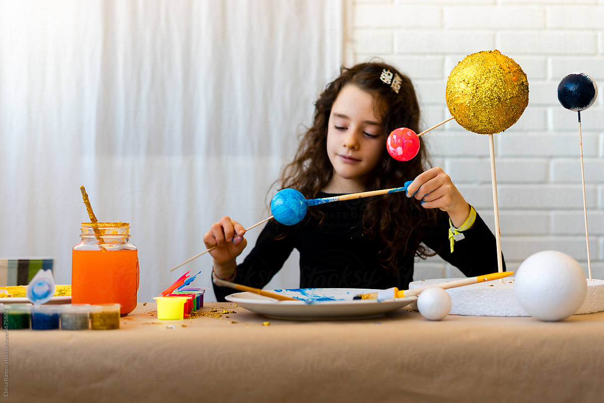 Young girl painting a handmade Solar System Craft For Science at home