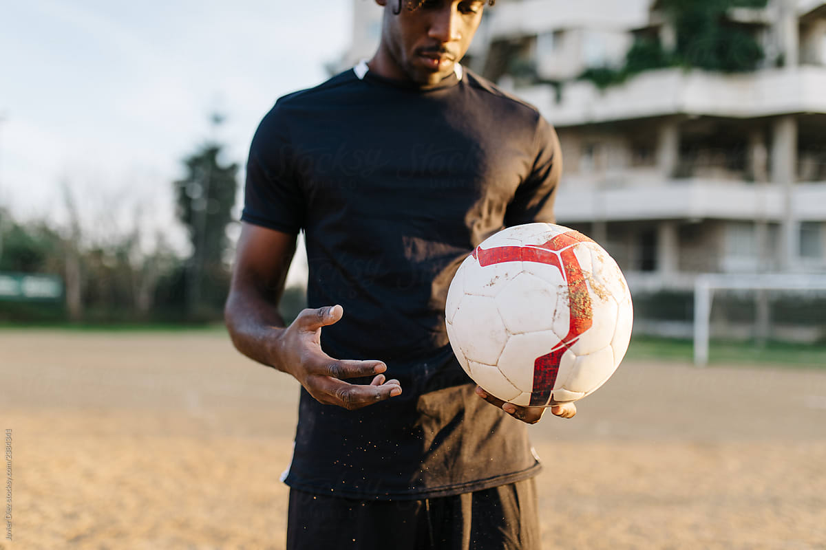 African American man holding ball on playground
