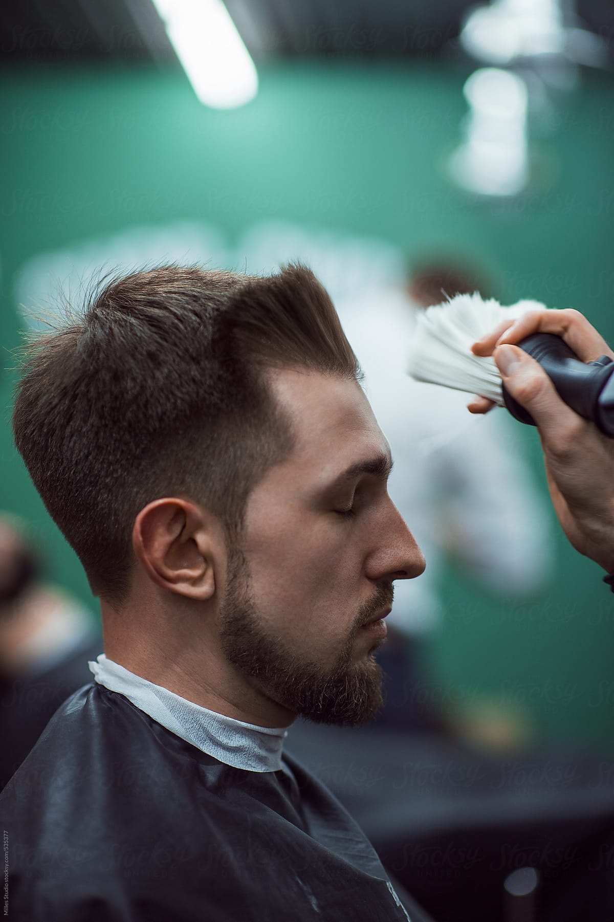 Barber cleaning face with brush to Client