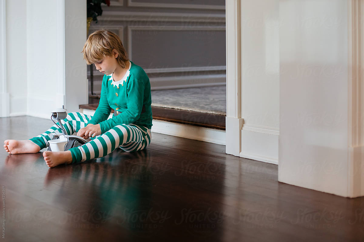 Boy in elf pajamas playing with robot toy