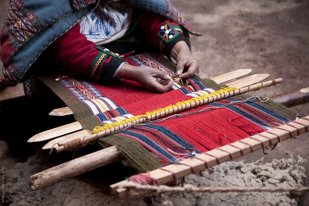 Peru: woman weaving intricate llama wool garments using a traditional hand loom