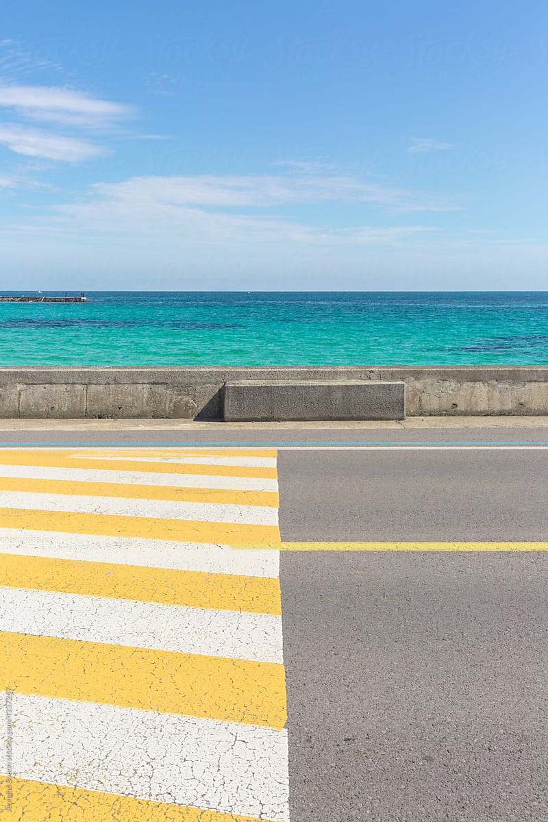 Beach and yellow striped road