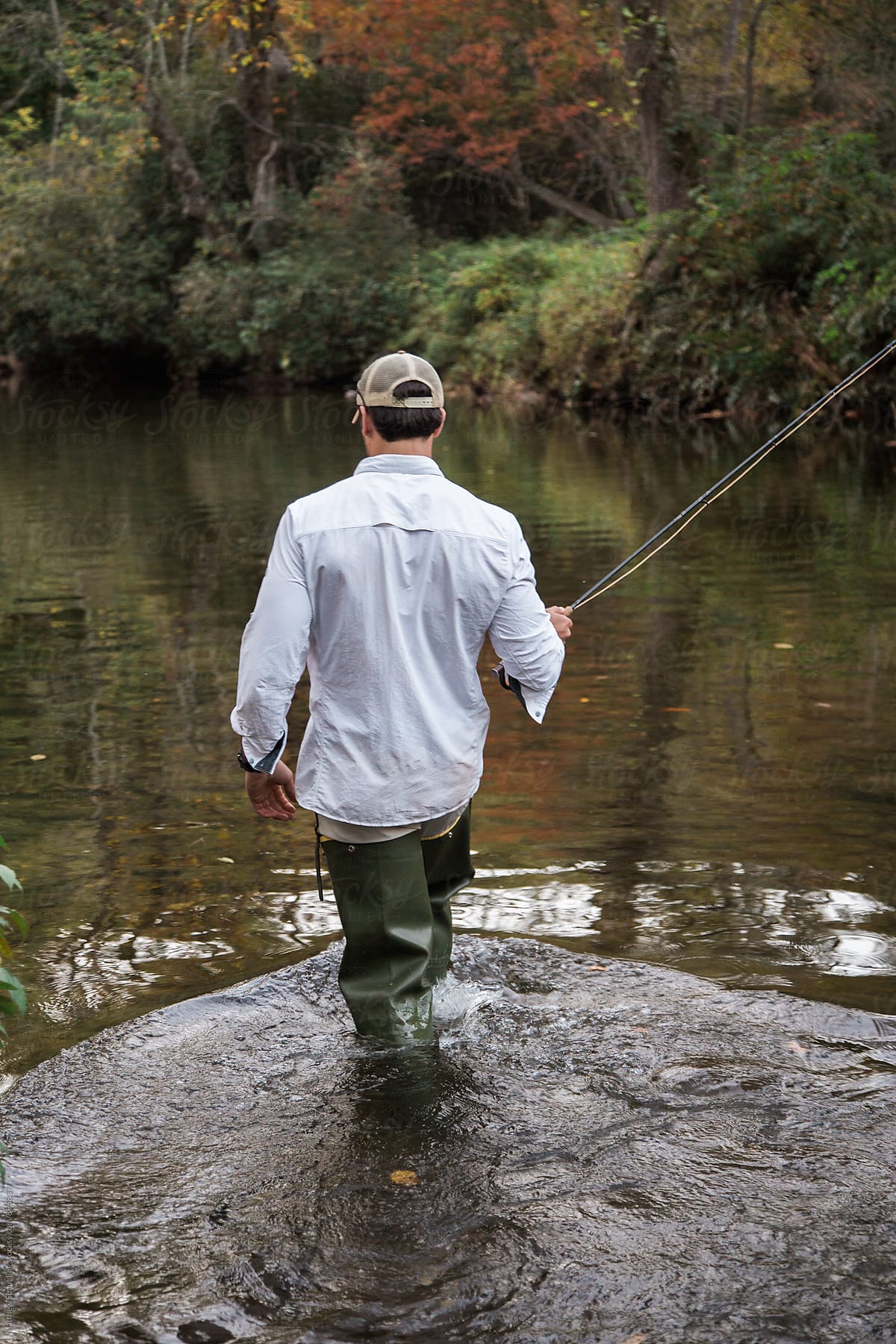 Fisherman Fly-fishing And Wading In Stream At Dusk by Stocksy Contributor Matthew  Spaulding - Stocksy