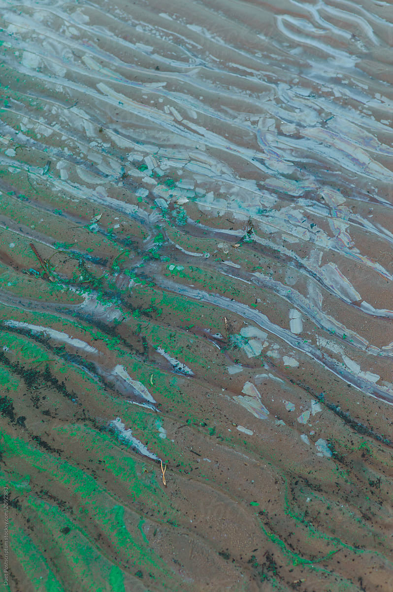 Green paint and water on sand. Oil or gas pollution.