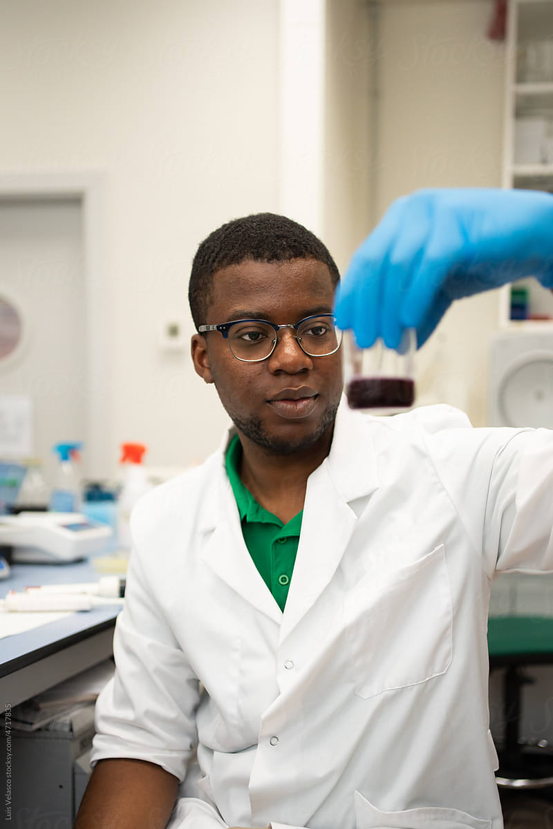 Black Scientist Checking A Tube In The Laboratory.