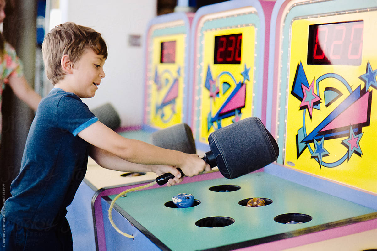 Boy playing whack a mole at a carnival
