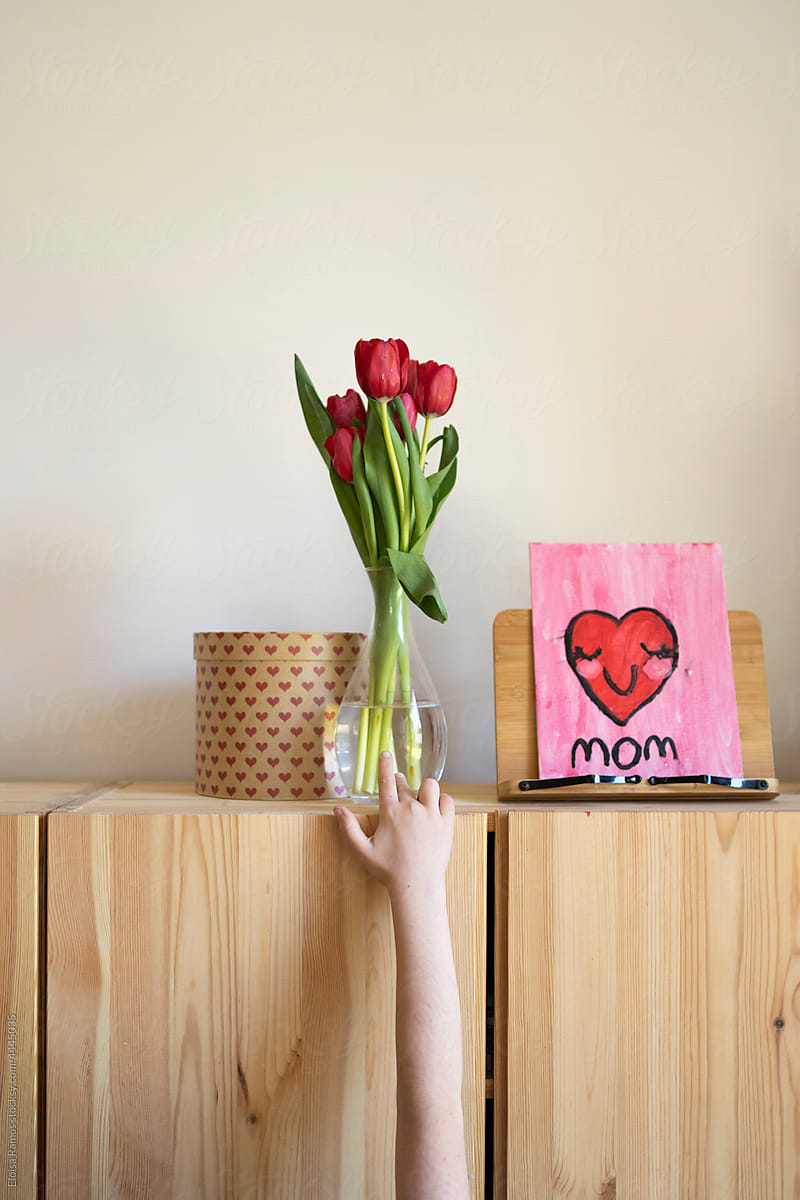Kid\'s hand showing gifts on furniture for mother\'s day