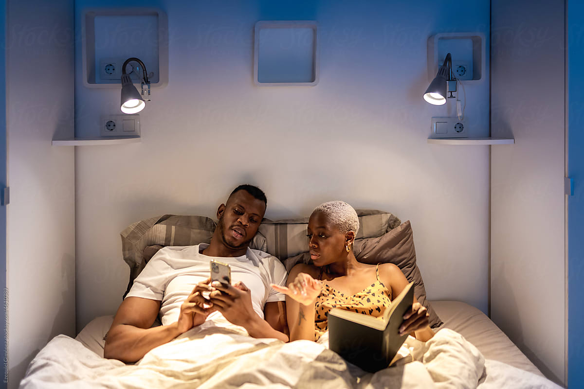 Black couple browsing social media at night together