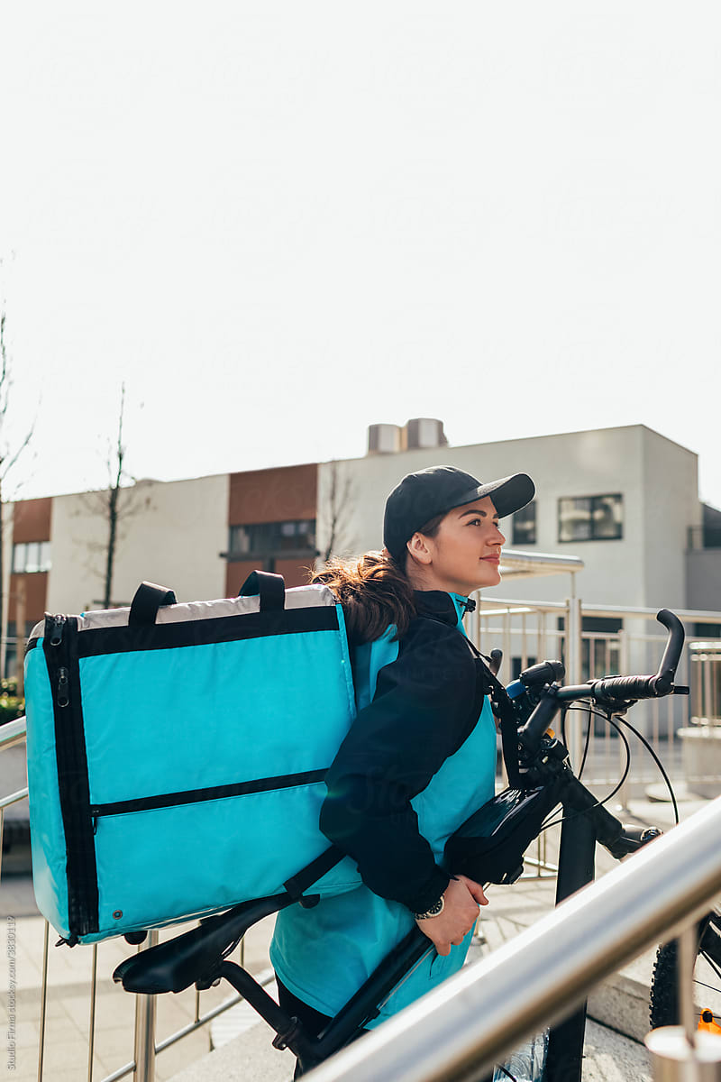 Delivery Girl Lifting Bicycle Up Stairs