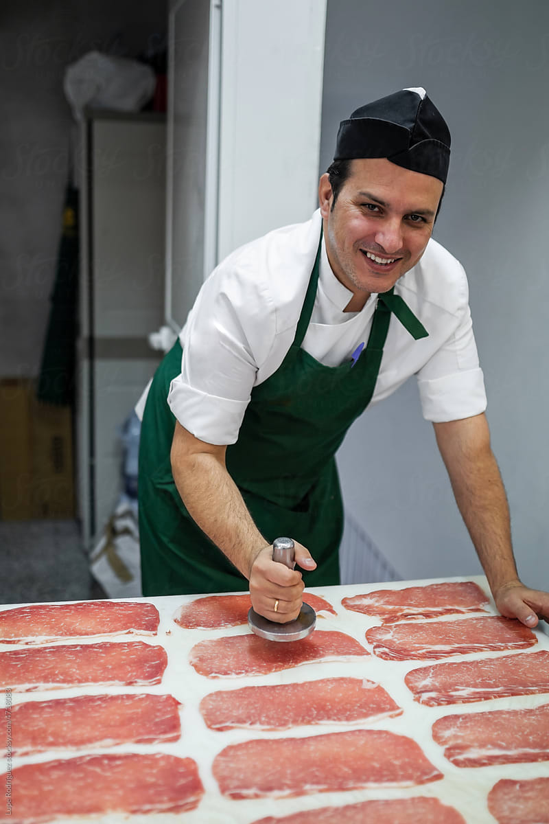 butcher preparing meat at a table in a butcher shop