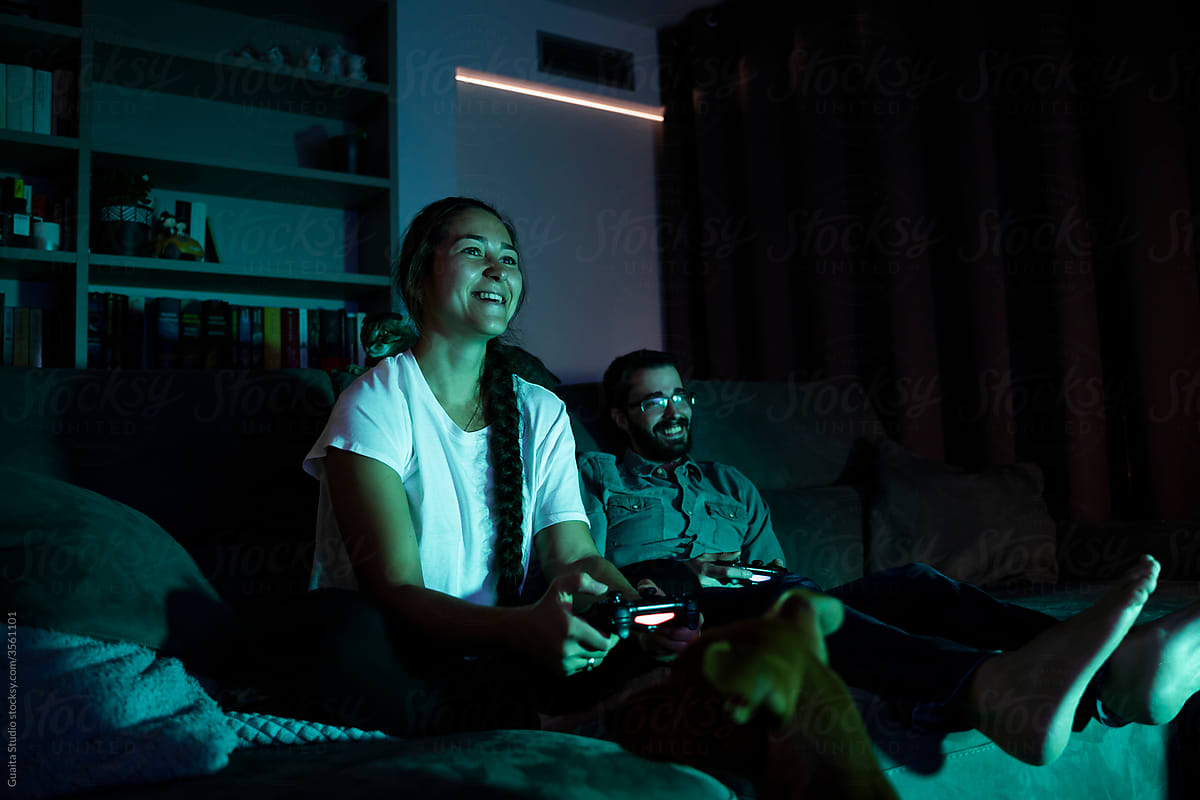 Focused couple playing videogames at night