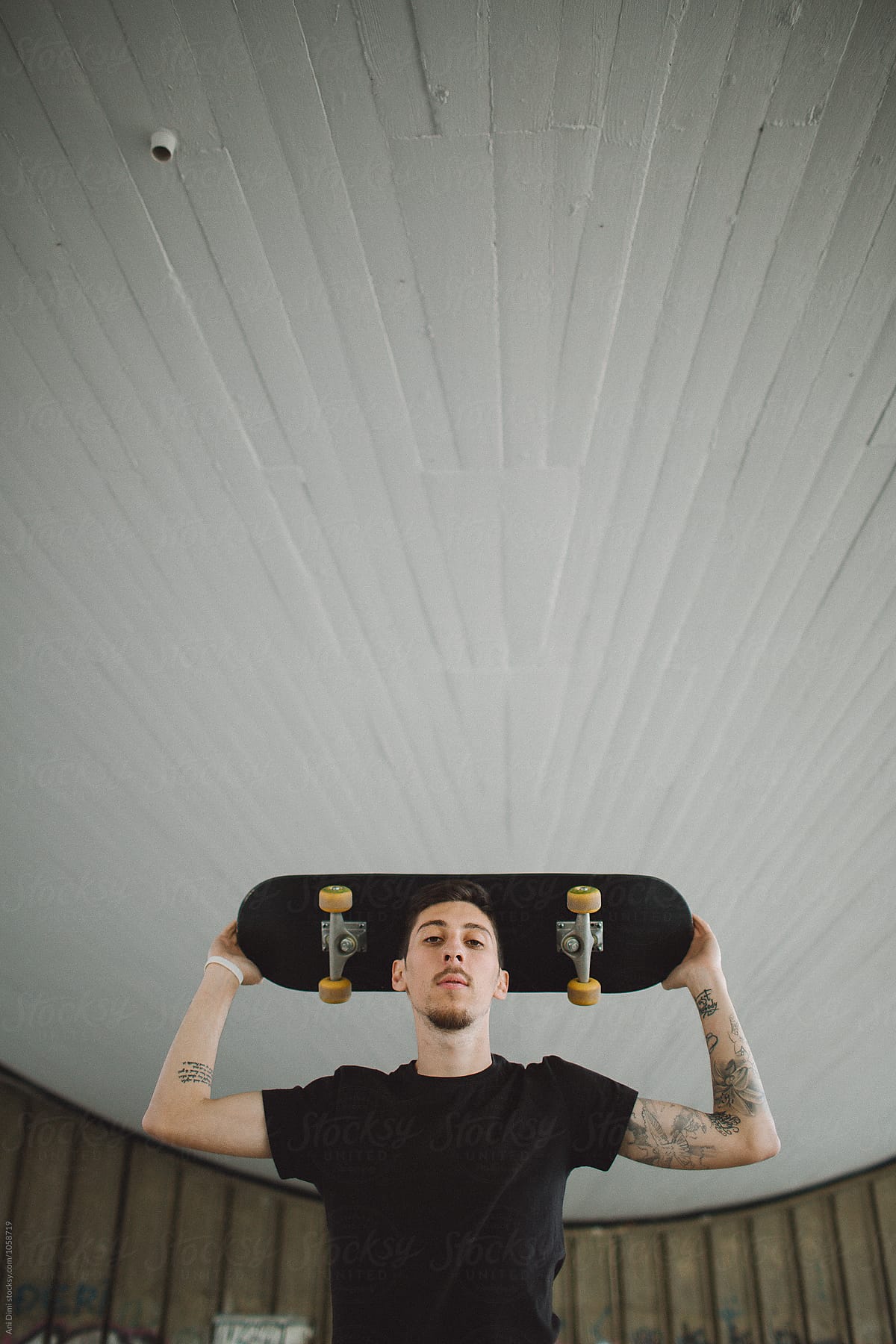 Portrait of male holding his skateboard