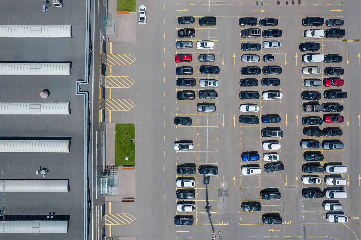 View from drone on parking lot with cars near commercial building