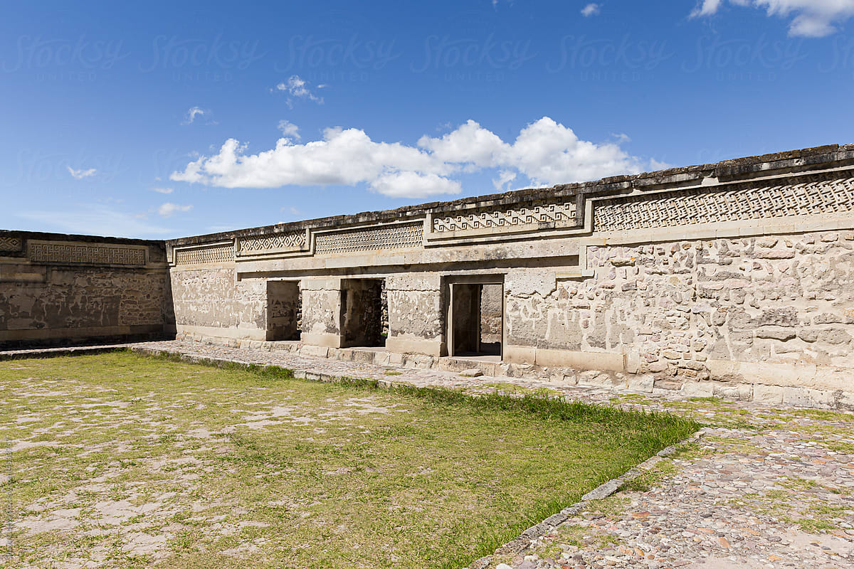 Patio with grass and walls of the archaeological ruins of Mitla