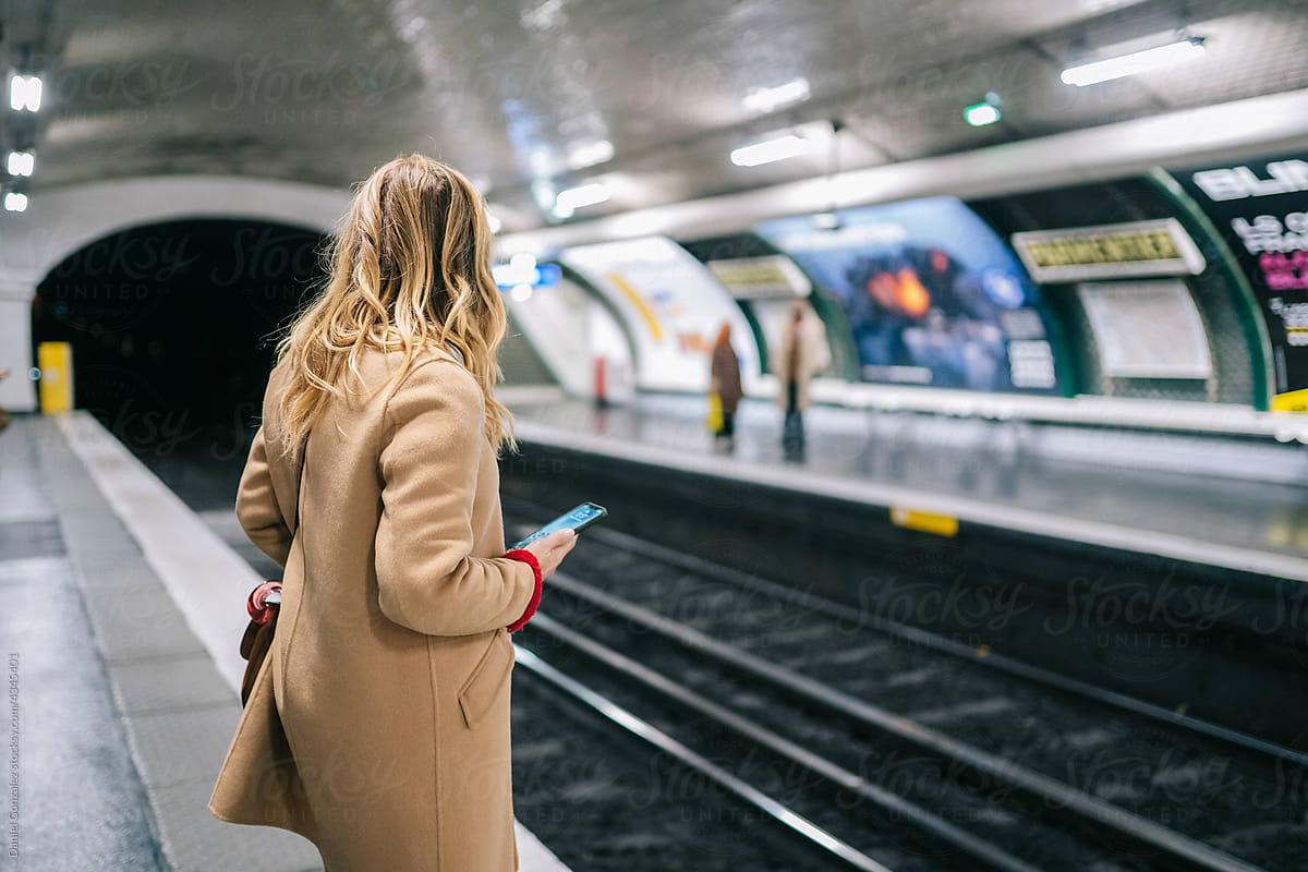 Anonymous woman with smartphone on platform