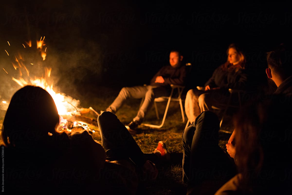 Friends Enjoying Their Time Around Campfire By Stocksy Contributor Boris Jovanovic Stocksy
