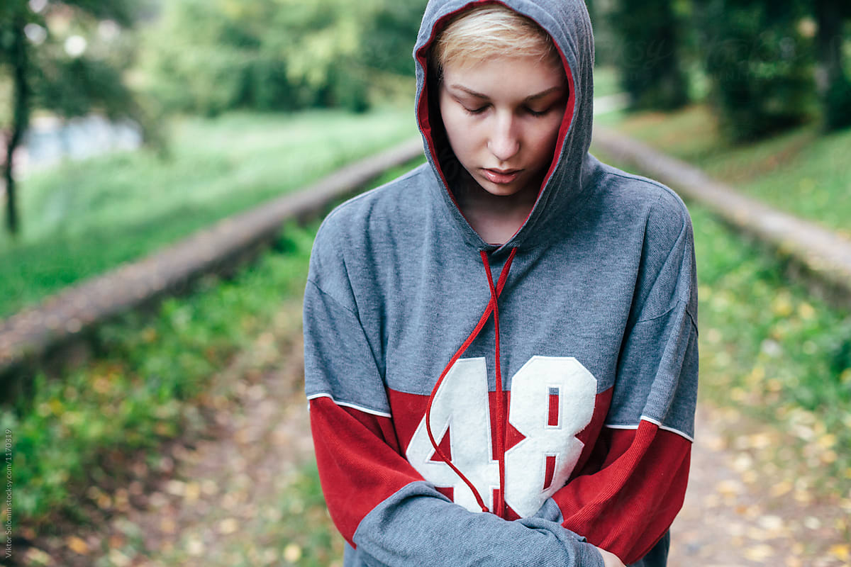 Young blonde woman posing in autumn in park dressed in hoodie