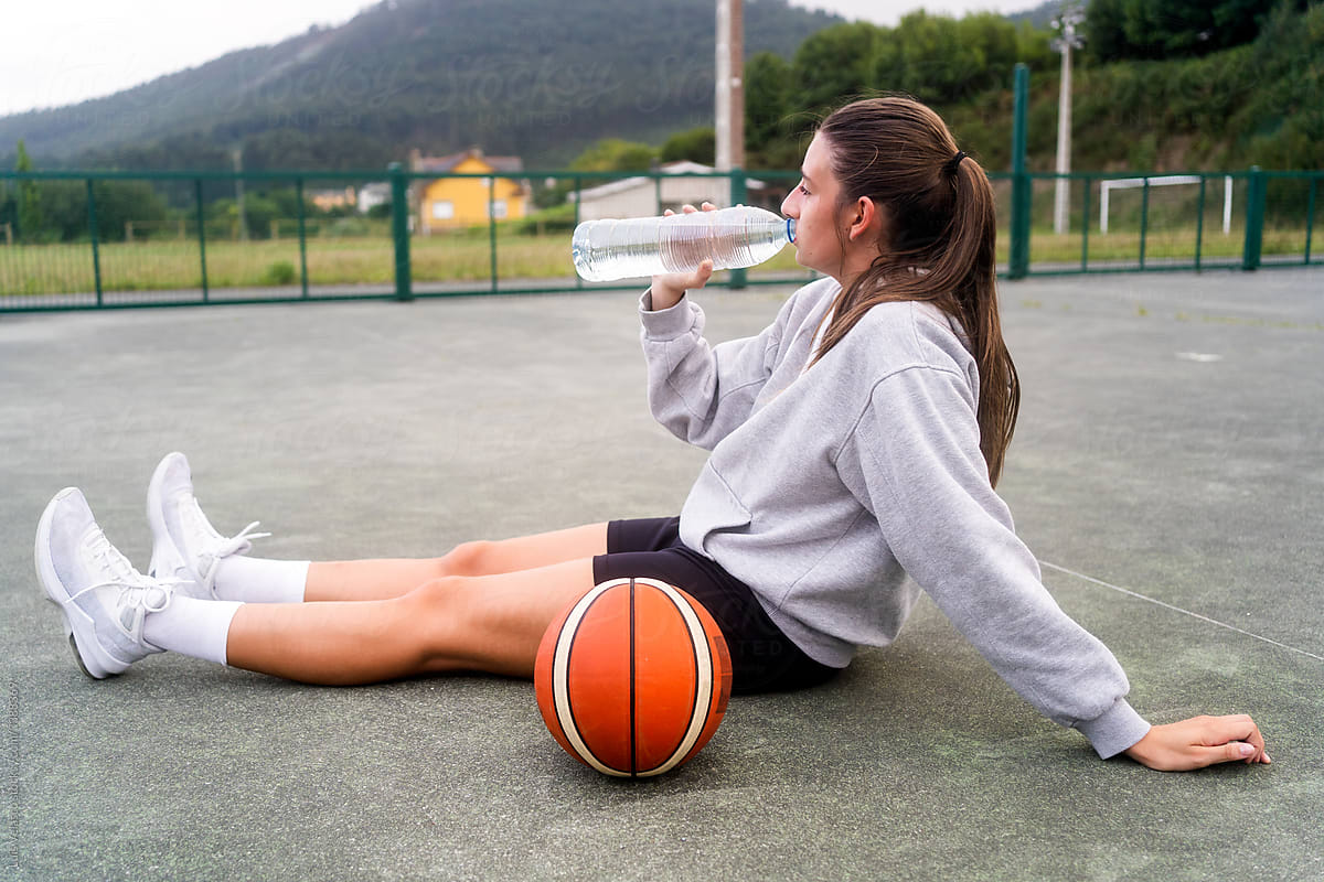 Girl Drinking Water After Playing Basketball.