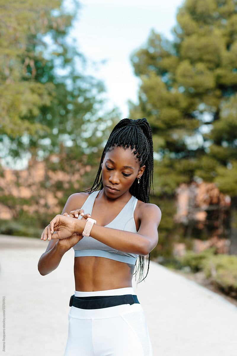 Sporty woman setting her smartwatch before starting her training.