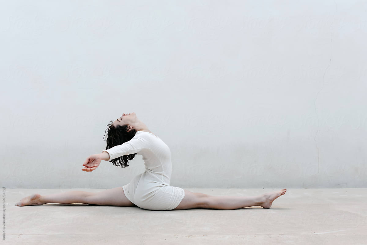Brunette Spreading Arms And Doing Split by Stocksy Contributor Tania  Cervian - Stocksy