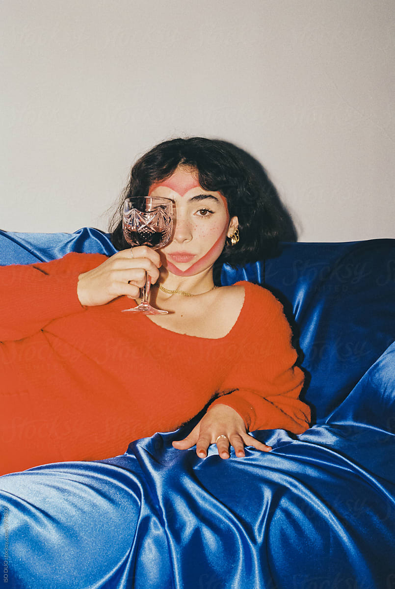 Portrait of Woman in Red Clothing holding a glass of wine
