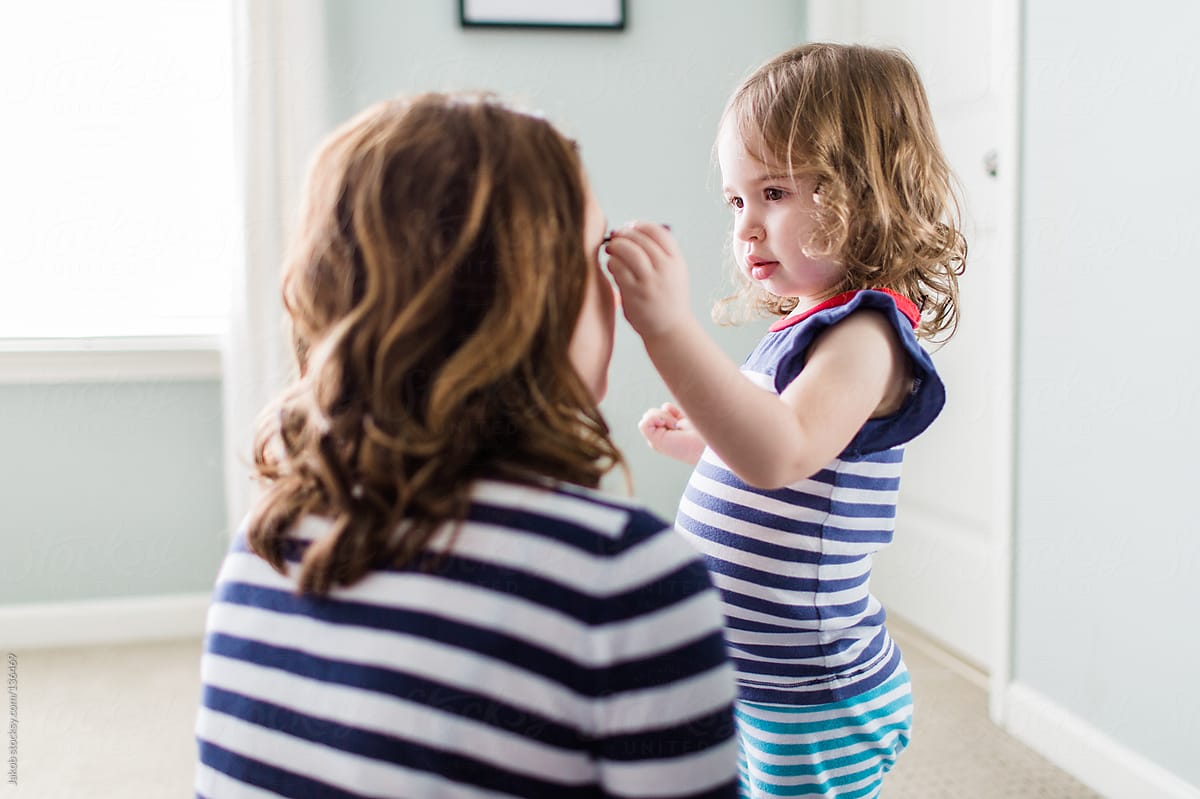 Mother And Baby Daughter Playing With Make Up In The Bedroom By Stocksy Contributor Jakob