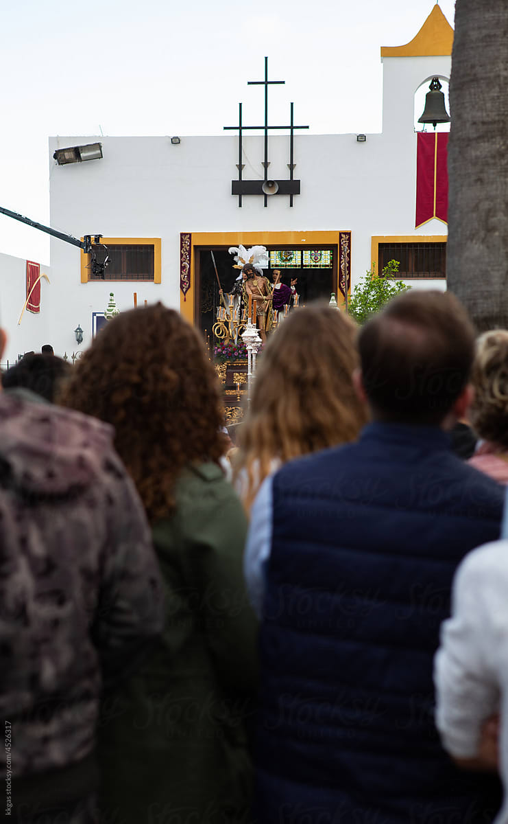 Idol exits the church during Semana santa. Members of the town watch
