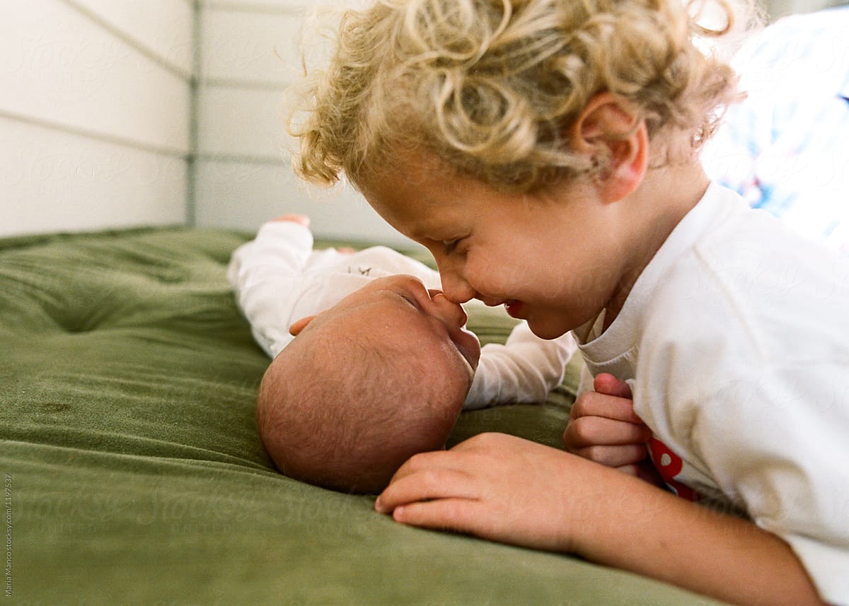 boys touches noses to baby sister