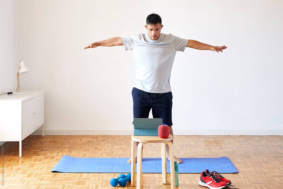 Man with Down syndrome exercising near tablet