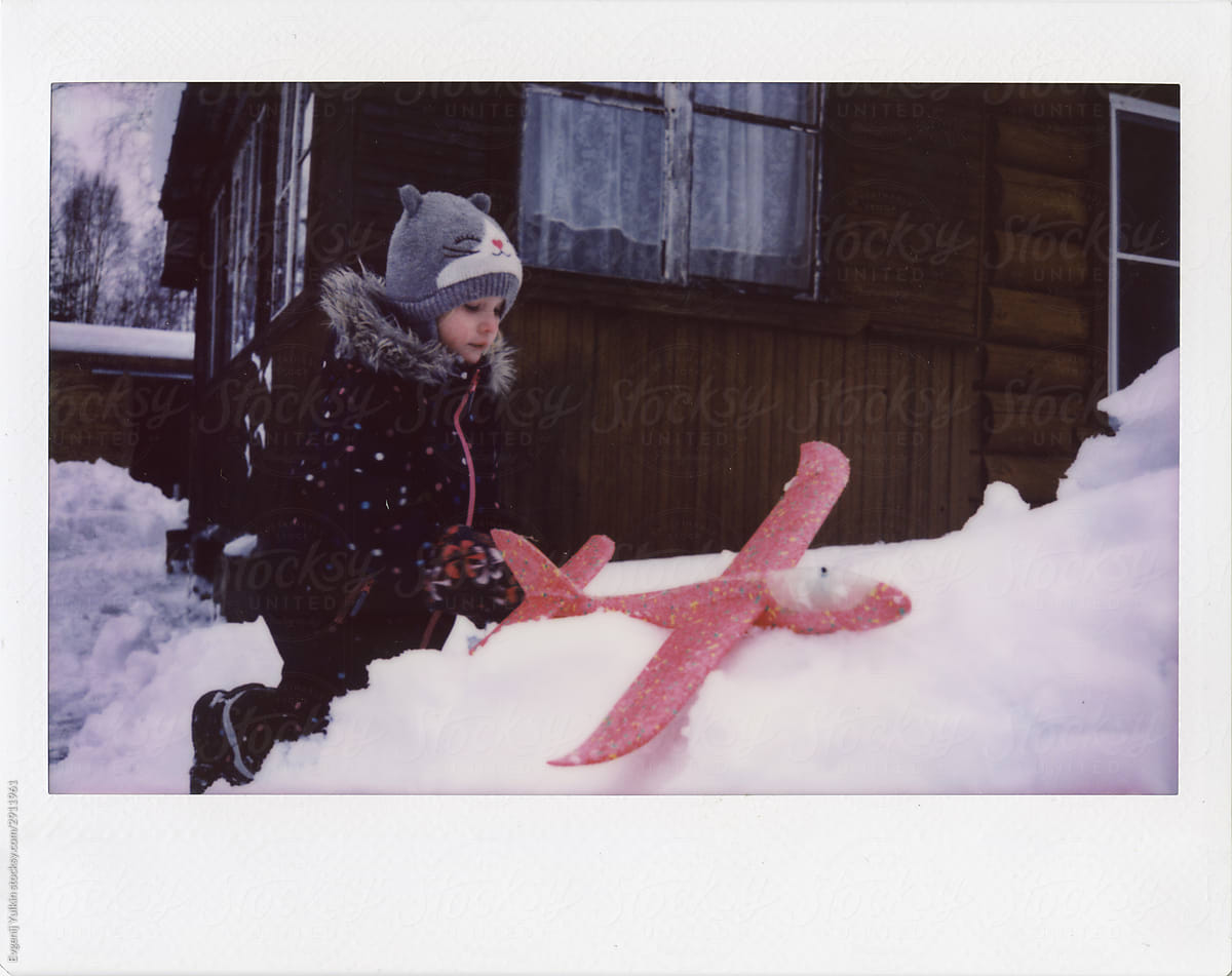 Child and toy plane in snow