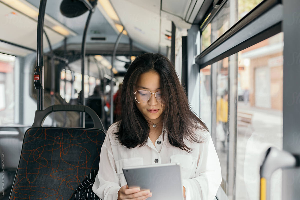 Asian woman in Bus with tablet
